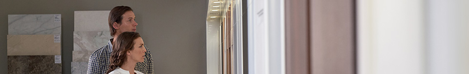 man and woman looking at sample cabinet doors on a gallery wall